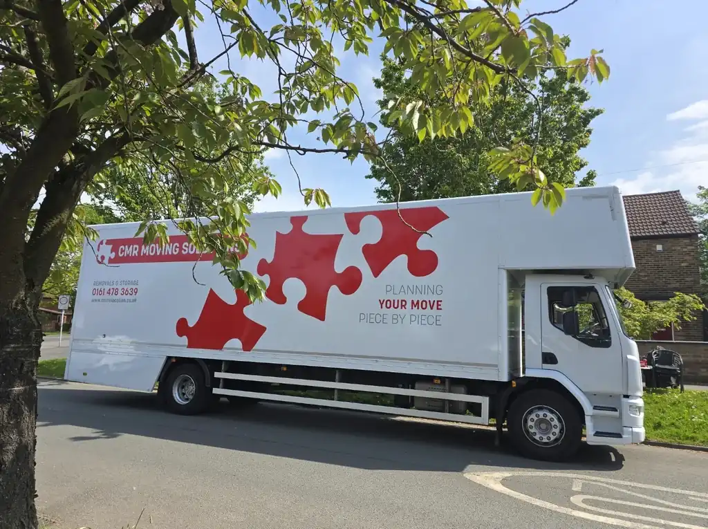 CMR Relocation removal lorry in puzzle-piece livery on a quiet road