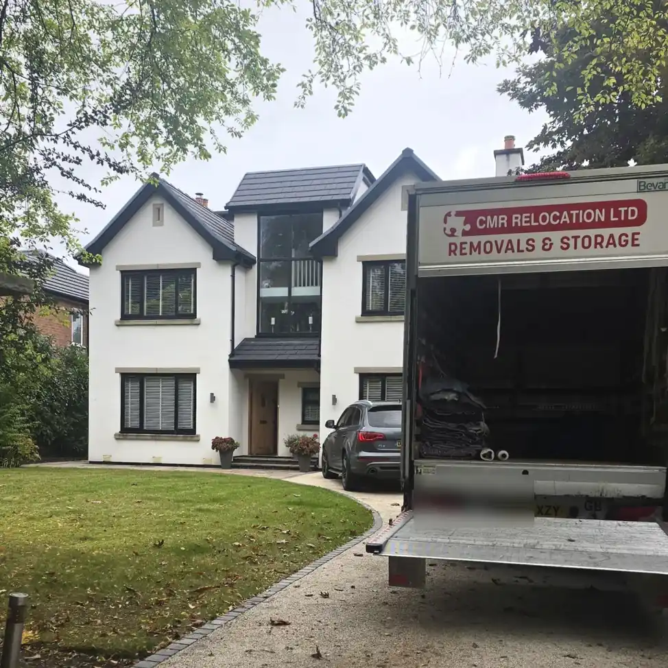 CMR Relocation lorry with its tail lift down outside a white detached house