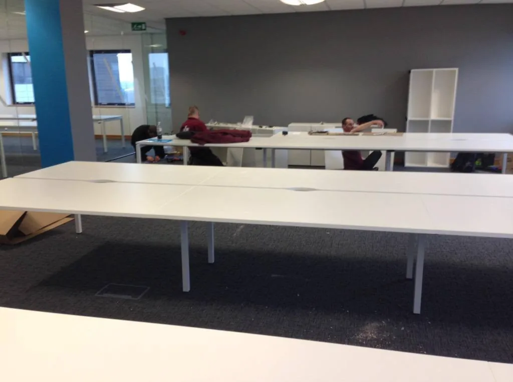 CMR Relocation crew assembling white bench desks in a new office