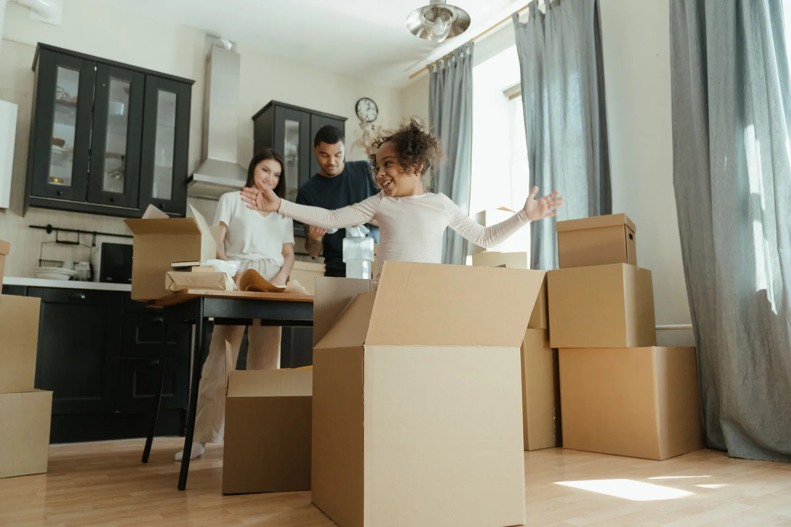 Family with a young child unpacking boxes in a kitchen