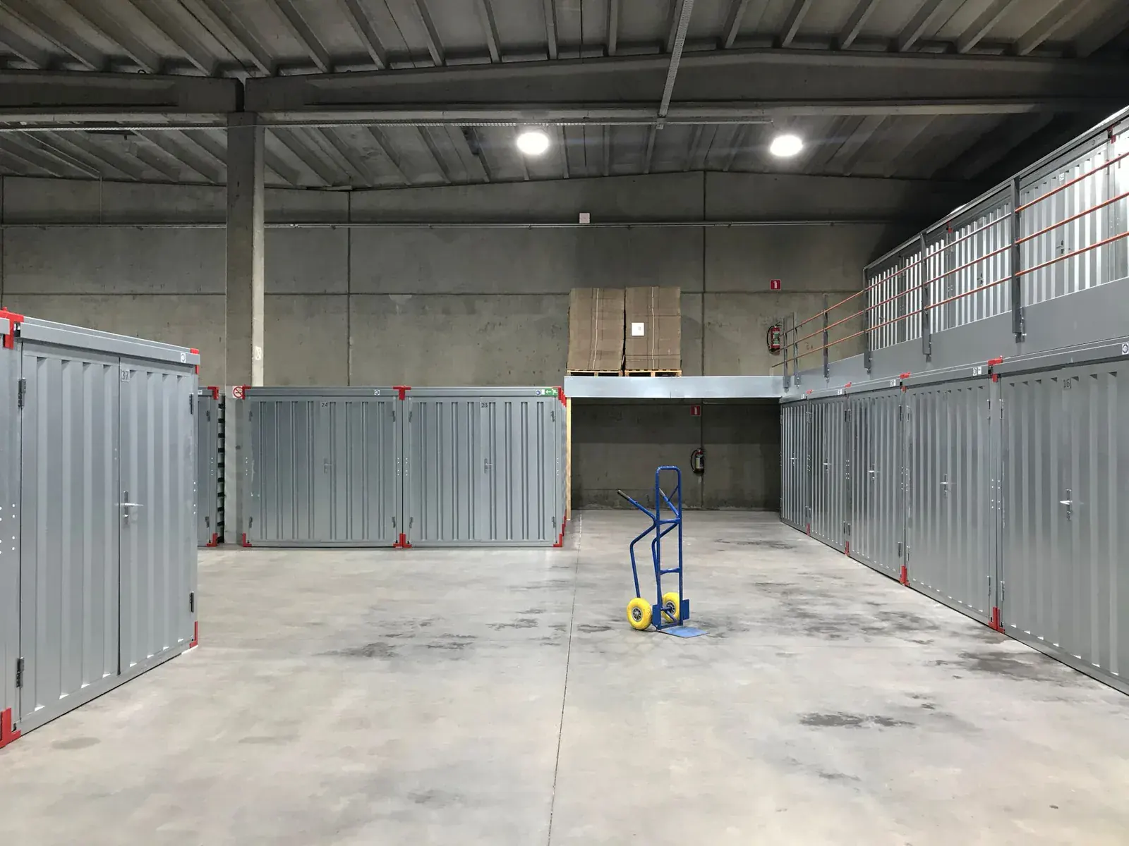 Rows of storage units in a dry warehouse with a sack truck