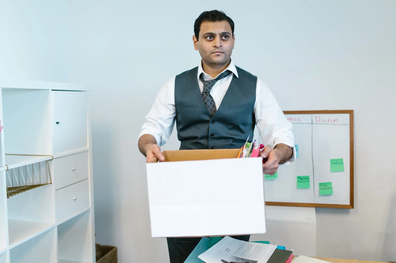 Man clearing office shelves at lease end to limit office dilapidations