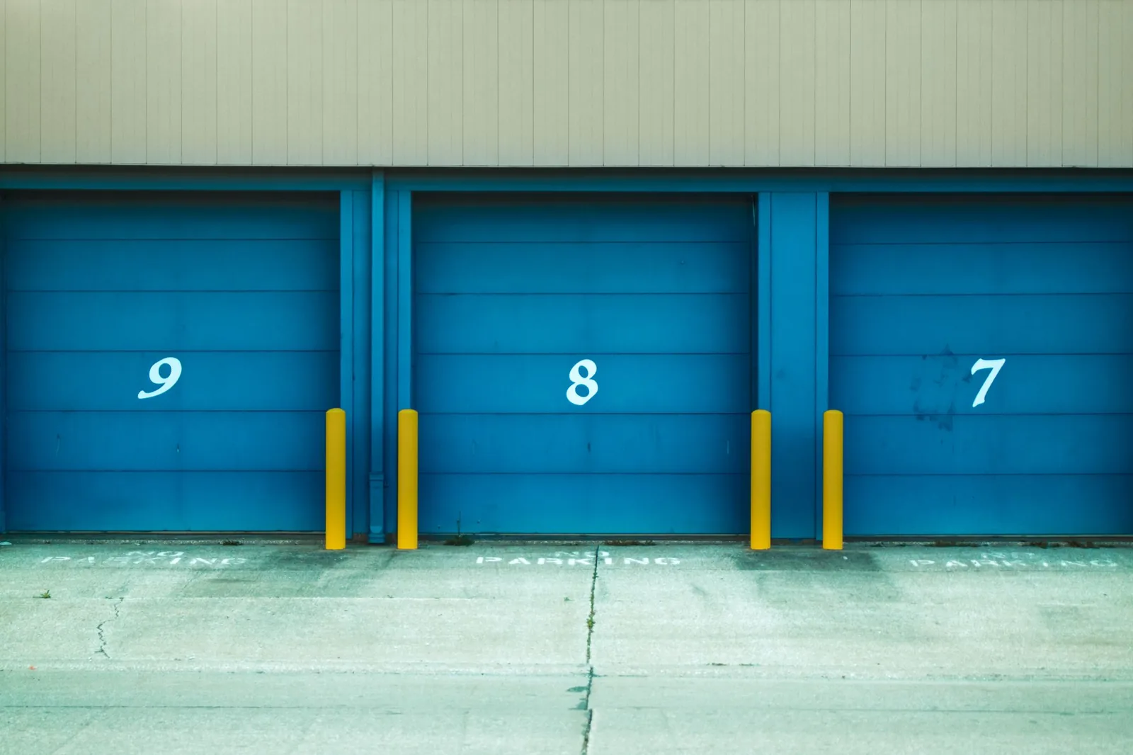 Row of numbered blue roller doors on storage units