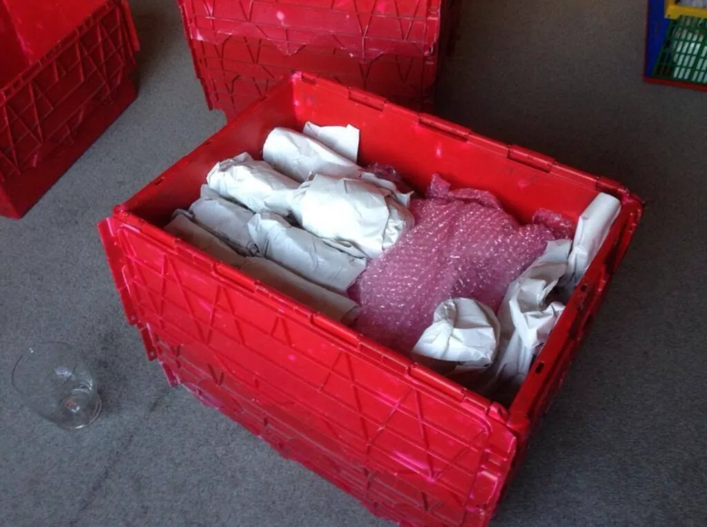 Red removal crate packed with wrapped glassware
