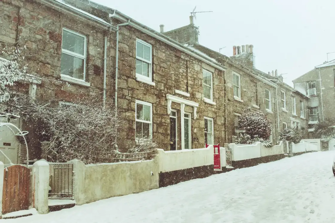 Stone terraced houses on a street covered in snow
