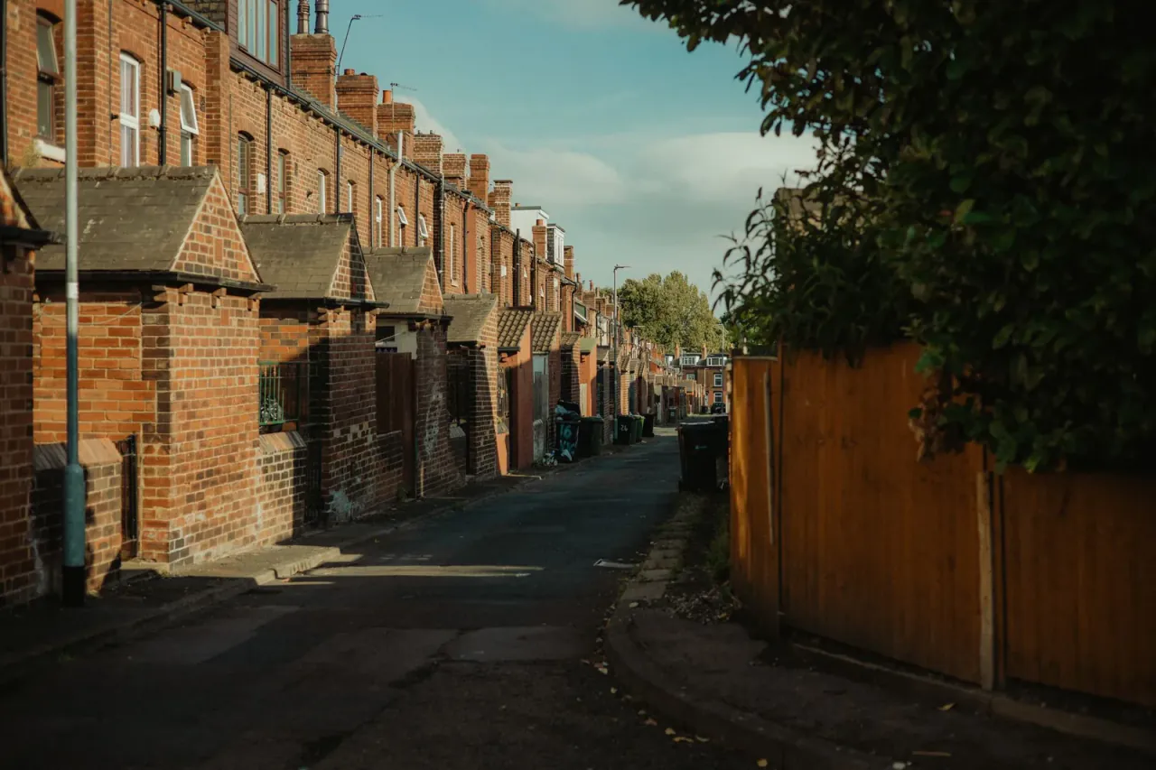 Back alley behind a row of red-brick terraced houses