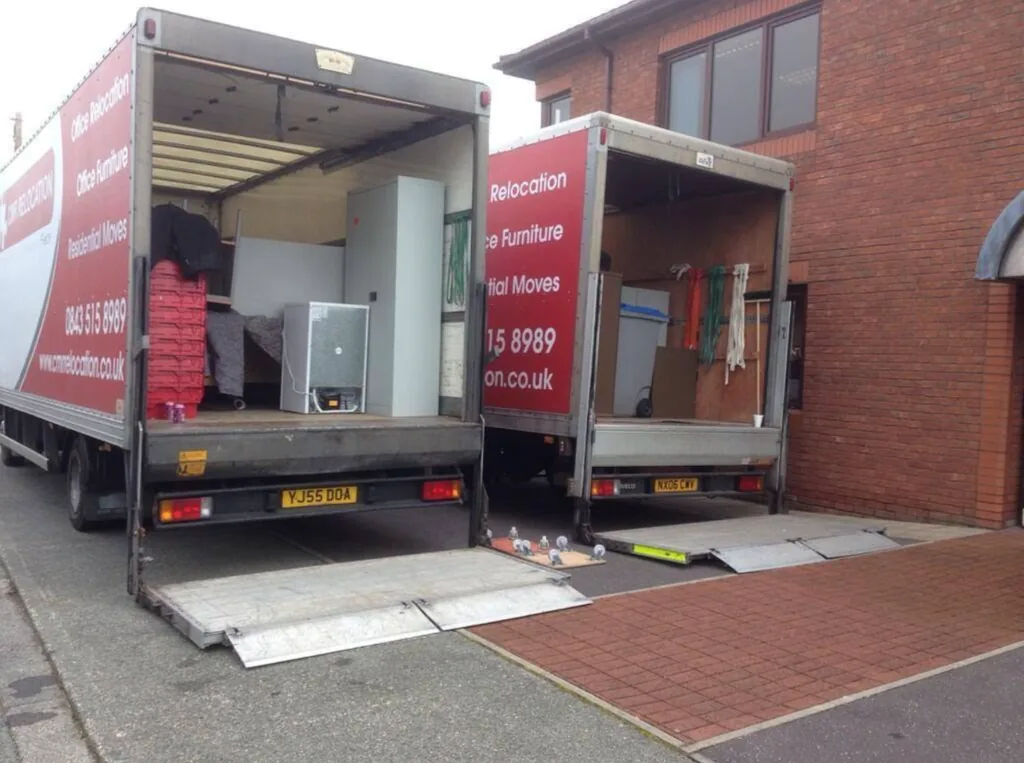 Two CMR Relocation lorries with tail lifts lowered while loading